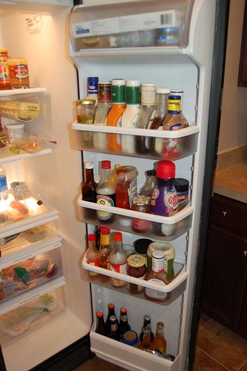 The inside of a refrigerator door that has tons of highly processed condiments and salad dressings.