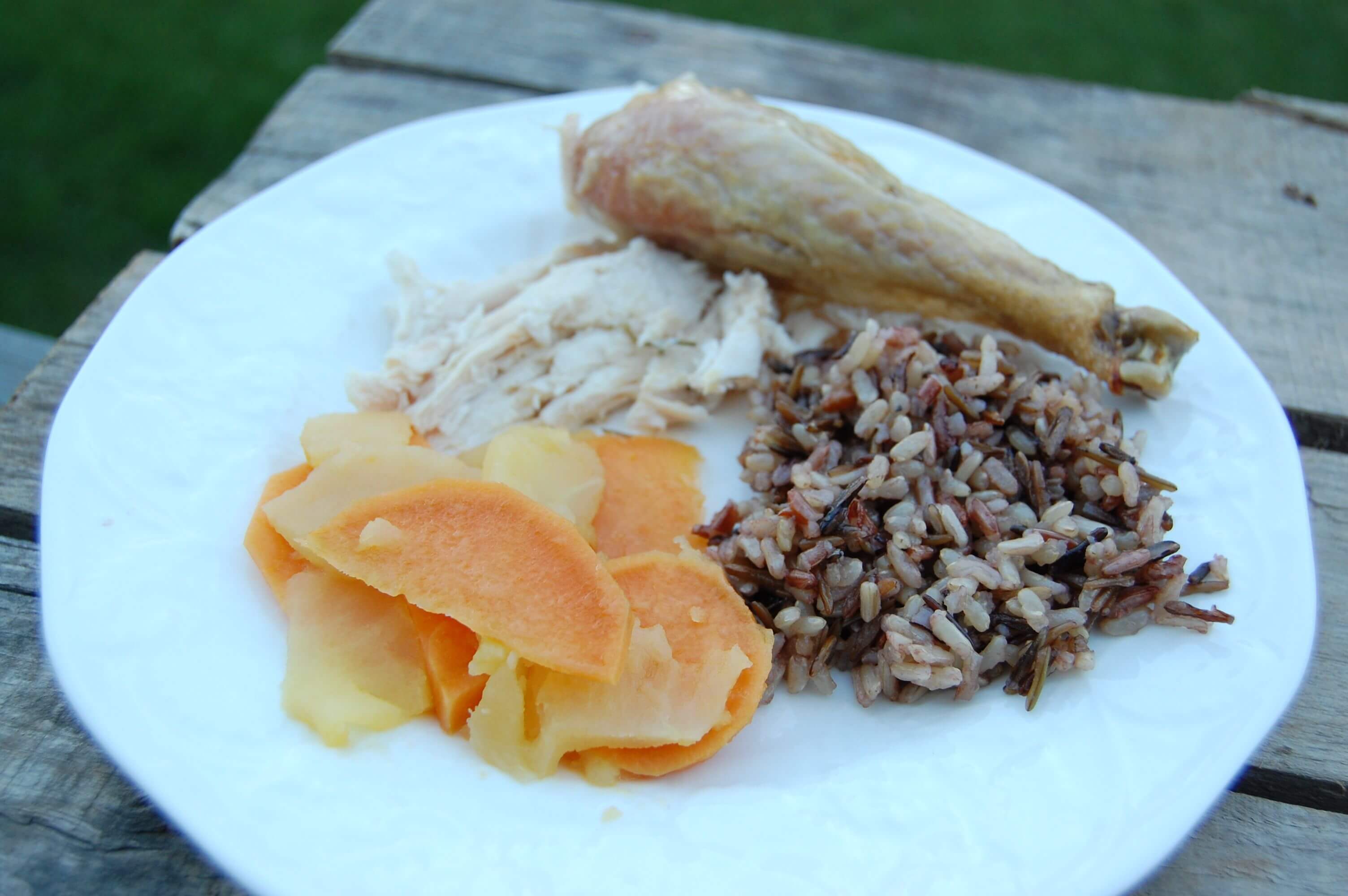 A plate of roasted chicken, wild rice, and sautéed sweet potatoes/apples.