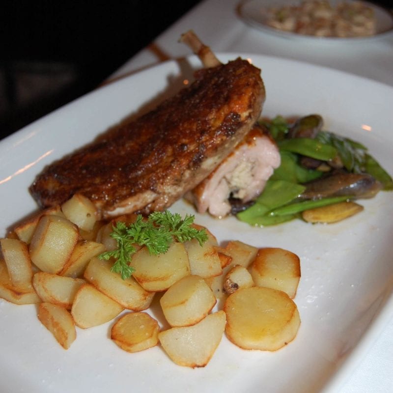 Moroccan Chicken with roasted potatoes and green beans on a plate served at Gotham Bar & Grill in NYC.