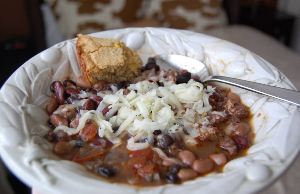 Homemade chili in a bowl topped with cheese.