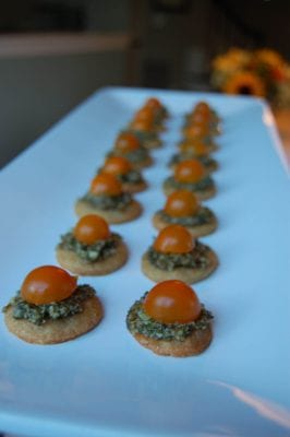 Homemade parmesan cheese crisps topped with pesto and sun gold tomatoes.