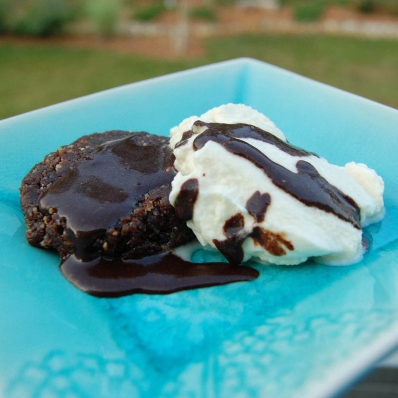 A chocolate dessert with whipped cream and chocolate sauce on a plate.