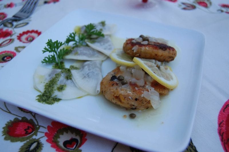 Raviolis made with raw turnips and chickpea cakes plated with pesto, parsley, and lemons.