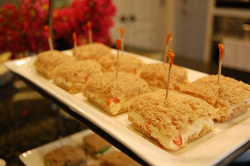 Pimento cheese and cucumber dill tea sandwiches on a plate.