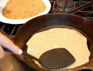 cooking a flour tortilla in a cast iron skillet