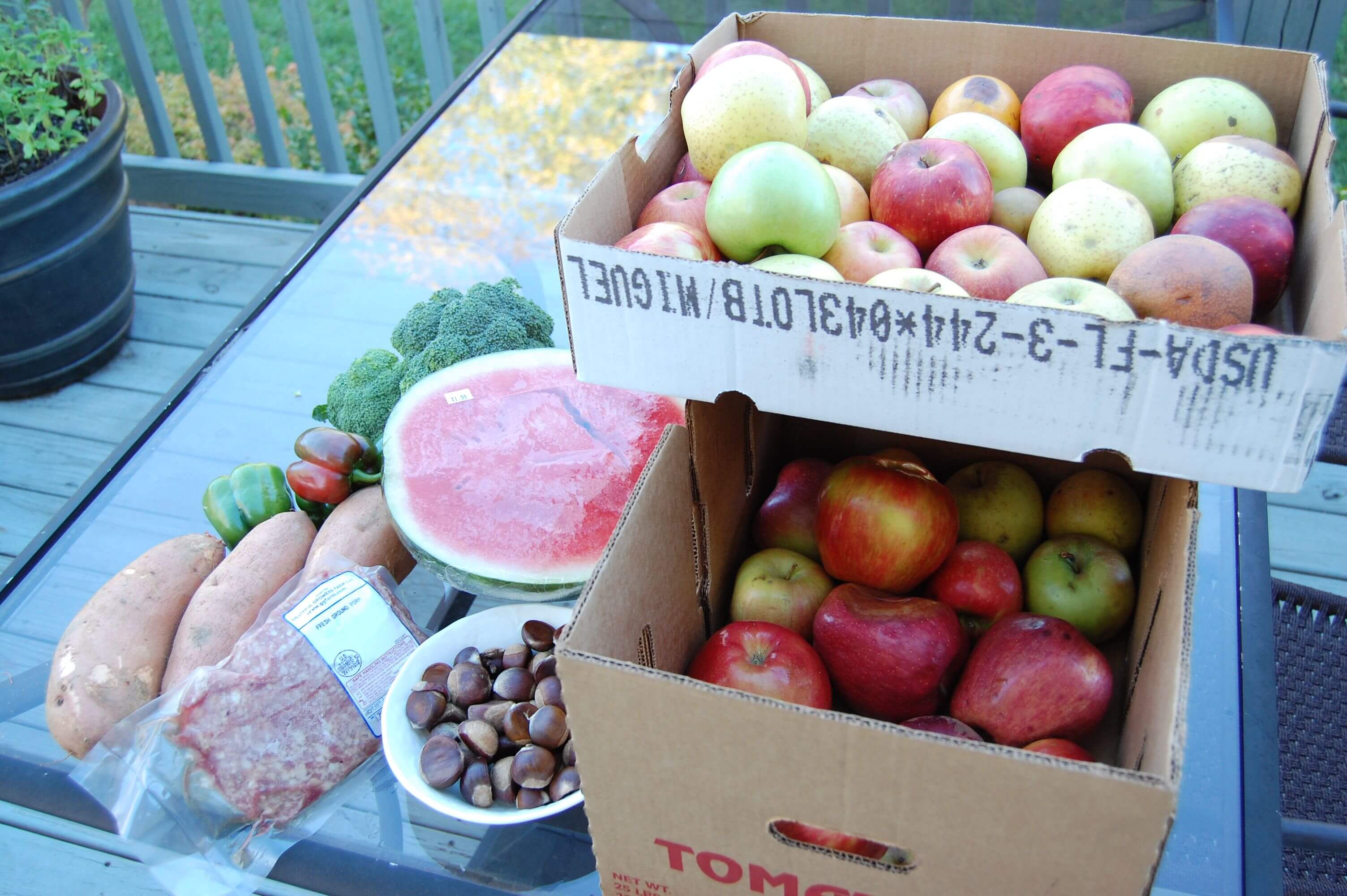 Boxes of apples, watermelon, sweet potatoes, broccoli, meat, and some nuts from the Hillbilly Produce in North Carolina.