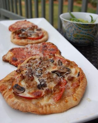 Homemade pizza with mushrooms and sausage on a plate.