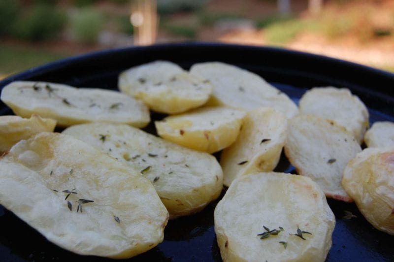 Oven-roasted potatoes sprinkled with thyme on a plate.