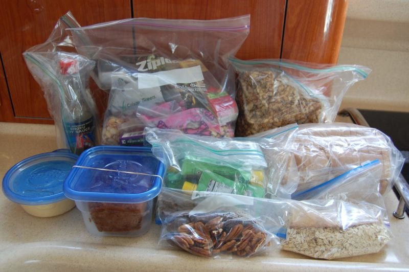 Homemade food and snacks packed in ziplock bags and plastic containers.